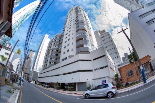 un coche está estacionado frente a un edificio en Apartamento Pontal Norte Ao Lado Da Big Wheel, en Balneário Camboriú