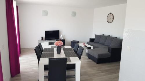 a dining room with a table and a couch at Apartman LuMa in Baška Voda