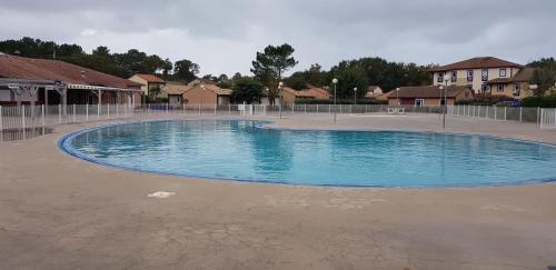 une piscine vide dans un quartier résidentiel dans l'établissement Résidence VILLAS DU LAC, à Soustons