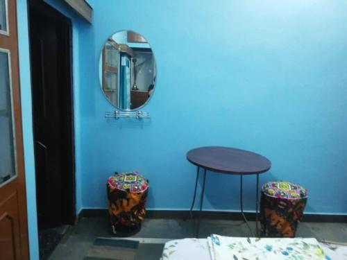 a blue room with a mirror and a table and stools at Om Trance Hostel in Jaipur