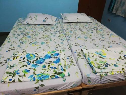 a bed with blue flowers on it at Om Trance Hostel in Jaipur