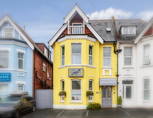 una casa amarilla en medio de algunos edificios en The Ravensbourne Hotel en Bournemouth