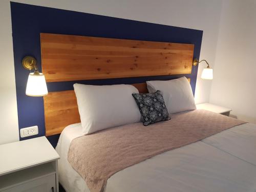 een slaapkamer met een bed met een blauw hoofdeinde en 2 kussens bij view point family suite in Eilat