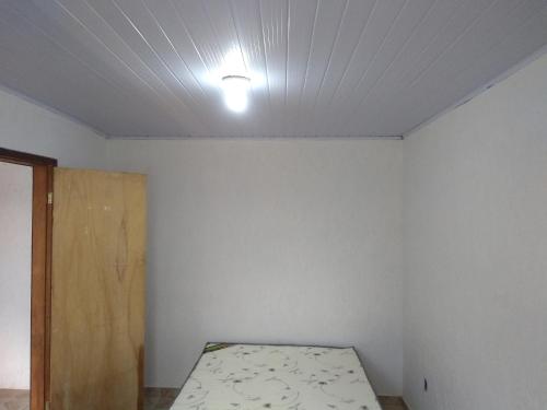 um quarto com uma cama e uma luz no tecto em Casa de Praia / Cabo Frio em Tamoios