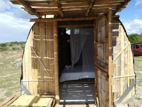 a small wooden hut with a bed in it at biohotel tatacoa Qji in Villavieja