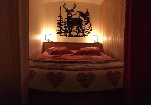 - une chambre avec un lit avec un cerf sur le mur dans l'établissement le coin tranquille, à Aime La Plagne
