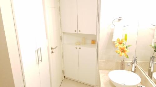 a white bathroom with a toilet and a sink at PENTHOUSE CON TERRAZA PARRILLERO Y JACUZZI PROPIO, PREMIADO POR AWARD SEGUNDO AÑO CONSECUTIVO -Edificio Jardins Del Est San Rafael- in Punta del Este