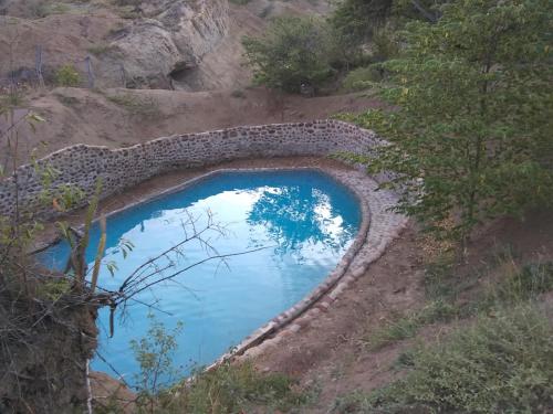 a pool of water in the middle of a hill at biohotel tatacoa Qji in Villavieja