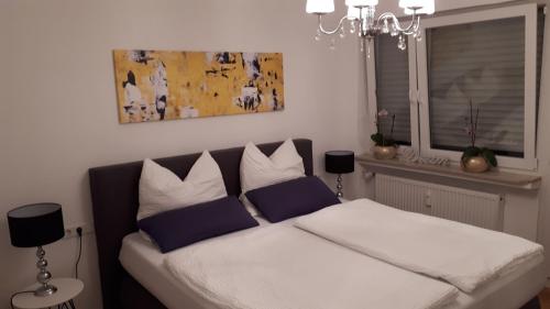 Schlafzimmer mit einem Bett mit blauen und weißen Kissen in der Unterkunft Das Platanenhaus - Ferienwohnung am Bodensee in Friedrichshafen