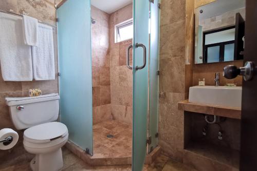 a bathroom with a shower and a toilet and a sink at Coral Island Beach View Hotel in Mazatlán