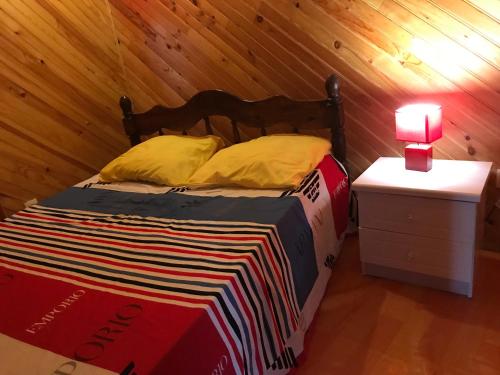 Appartement du Chalet في Koungou: سرير في غرفة ذات جدار خشبي