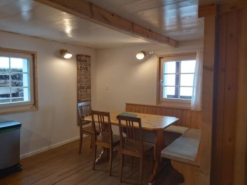 a dining room with a wooden table and chairs at Tgèsa Felici in Sedrun