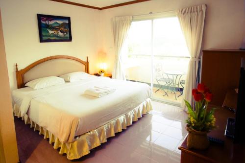 - une chambre avec un grand lit et une grande fenêtre dans l'établissement The Residence Hotel -SHA Extra Plus, à Chiang Mai