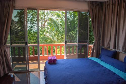 a bedroom with a blue bed and a large window at Comfosya BBQ Pool Villa near Jomtien Beach in Na Jomtien