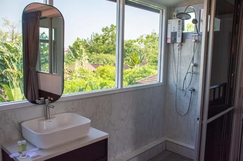a bathroom with a sink and a mirror and a shower at Comfosya BBQ Pool Villa near Jomtien Beach in Na Jomtien