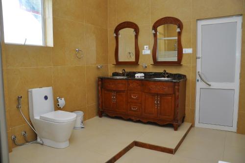 bagno con servizi igienici, lavandino e specchio di Hotel East Lagoon a Batticaloa
