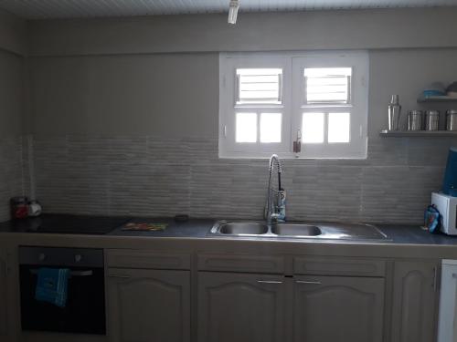 a kitchen with a sink and a window at VILLA CAPACITE 6 PERSONNES PROCHE PLAGES DU Sud in Rivière-Pilote