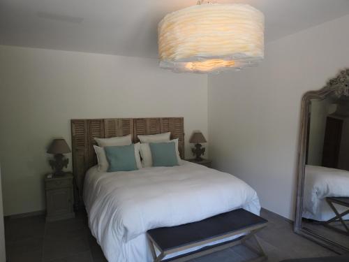 - une chambre avec un lit, un miroir et un lustre dans l'établissement La Cavale En Mer T4 100m², à Cavalaire-sur-Mer