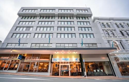 a large building on a street in front of a building at Scenic Hotel Southern Cross in Dunedin