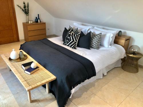 una camera da letto con un grande letto con cuscini e un tavolo di Luxurious duplex penthouse with golf and sea views a Benalmádena