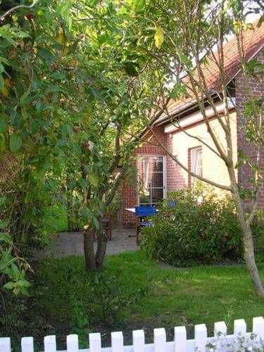 a white fence in front of a house at Ferienhaus Schonerweg 9 in Norddeich in Norddeich