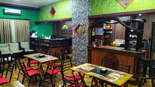 a restaurant with tables and chairs and a bar at Residencial Arcoiris in Puerto Iguazú