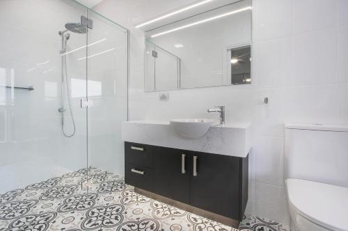 La salle de bains est pourvue d'un lavabo et d'une douche en verre. dans l'établissement The Apartment, Metung, à Metung