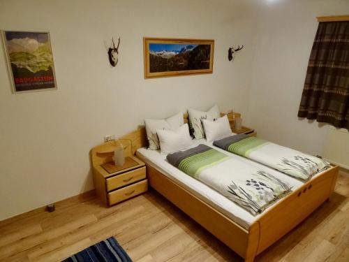 a bedroom with a twin bed with a night stand at Landhaus Rathgeb in Bad Gastein