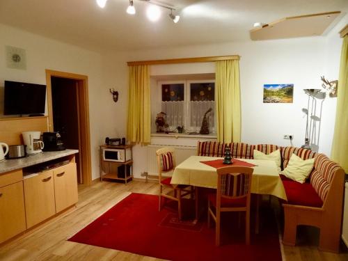 ein Wohnzimmer mit einem Esstisch und einer Küche in der Unterkunft Landhaus Rathgeb in Bad Gastein