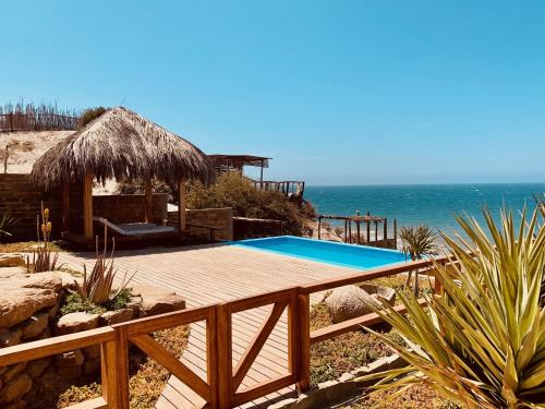 una piscina en una terraza junto al océano en La Playa en Los Órganos