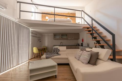 uma sala de estar com um sof branco e uma escada em Villa Alzira em Seia