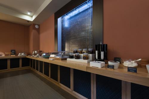 a restaurant with a counter with food items on it at Kentrikon Hotel in Lagadia