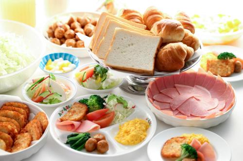 een tafel gevuld met verschillende soorten voedsel op borden bij Hotel Mount Shiga in Yamanouchi