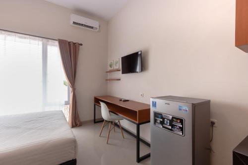 a hotel room with a bed and a desk with a computer at Omah Manis in Yogyakarta
