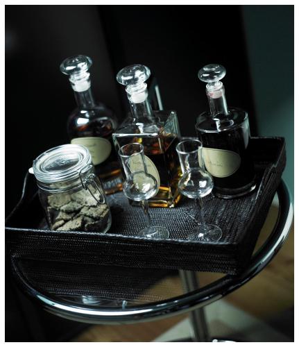 a tray with four bottles and glasses on a table at Relais & Châteaux Taubenkobel in Schützen am Gebirge
