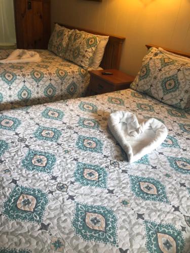 a bed with a heart pillow on top of it at Kennebunkport Motor Lodge in Kennebunkport