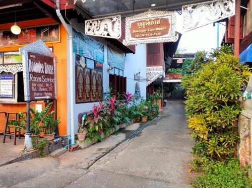 a street with plants and signs on a building at Boondee House in Mae Hong Son