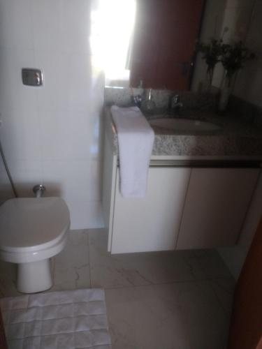 a bathroom with a white toilet and a sink at Casa novanova in Capitólio