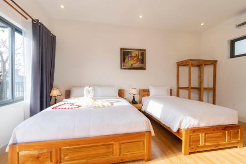 a bedroom with two beds and a window at Aurora House in Phu Quoc