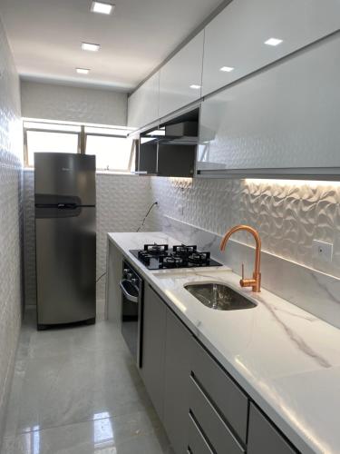 eine Küche mit einem Kühlschrank aus Edelstahl und einer Spüle in der Unterkunft Flat na Barra - Vista para o Mar in Rio de Janeiro