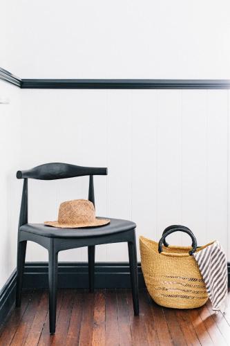 a chair and a straw hat next to a basket at Pacific Hotel Yamba in Yamba