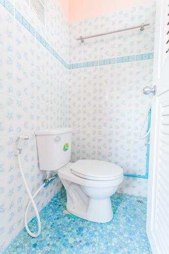 a bathroom with a white toilet in a room at Gaiwandhanat Homestay in Bangkok