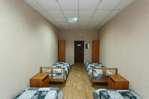 a room with four beds in a room with a ceiling at Gostinitsa on Martemyanova in Kemerovo