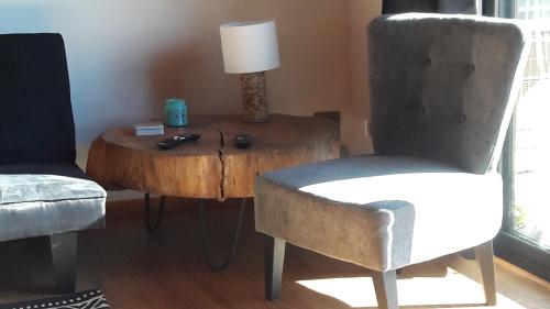 a living room with a chair and a table with a lamp at Valdivia, Cabañas camino a Niebla in Valdivia