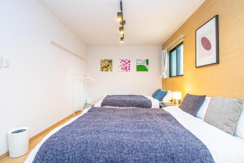 um quarto com 2 camas e um sofá em LA CHIC Stay Hakata em Fukuoka