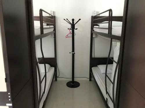 a room with three bunk beds and a mirror at Island Hostel Bayan Lepas Airport in Bayan Lepas