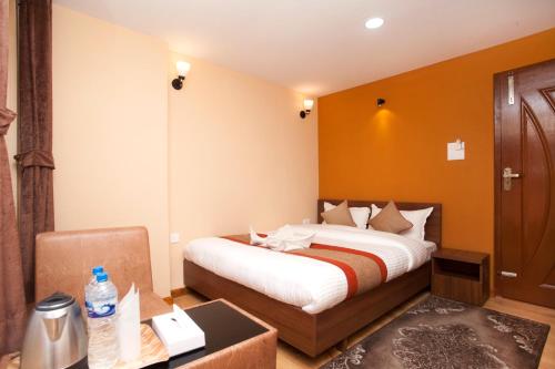 Pokój hotelowy z łóżkiem, biurkiem i pokojem w obiekcie Holiday Hostel w Katmandu