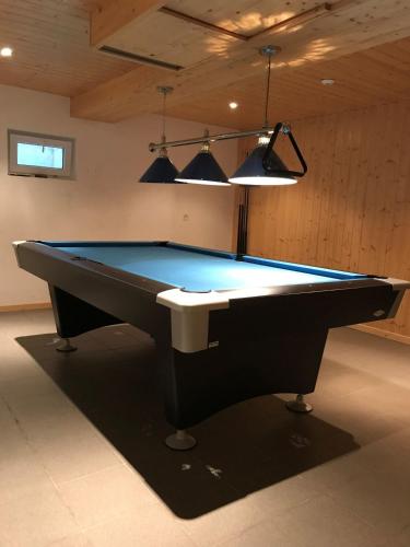 a black pool table in a room with lights at Edelweiss A13 in Morgins