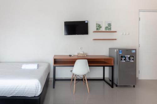 a bedroom with a desk with a bed and a chair at Omah Manis in Yogyakarta