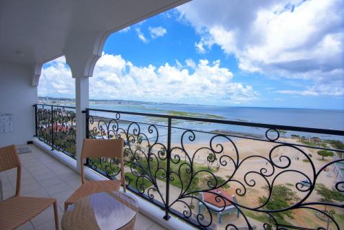 a balcony with chairs and a view of the ocean at Condominium Hotel Monpa in Chatan